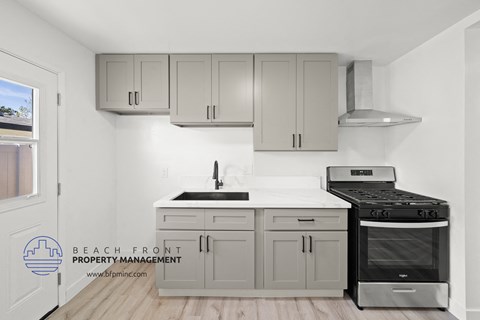 a kitchen with white cabinets and a black stove top oven